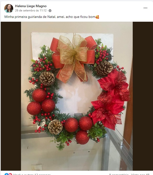Post de aluna: 'Minha primeira guirlanda de Natal, amei' — guirlanda vermelha e dourada com laço, pinhas e bolas.